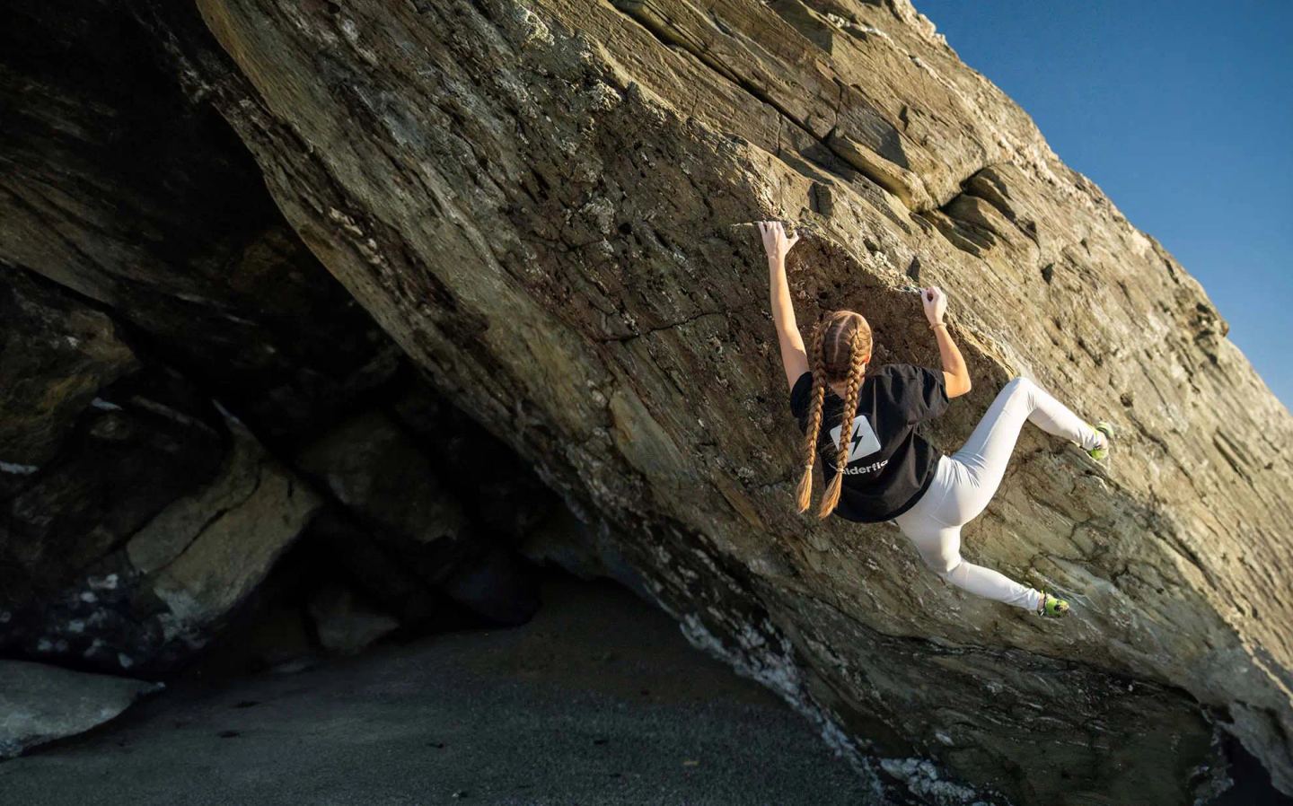 Climber bouldering outdoors on natural rock